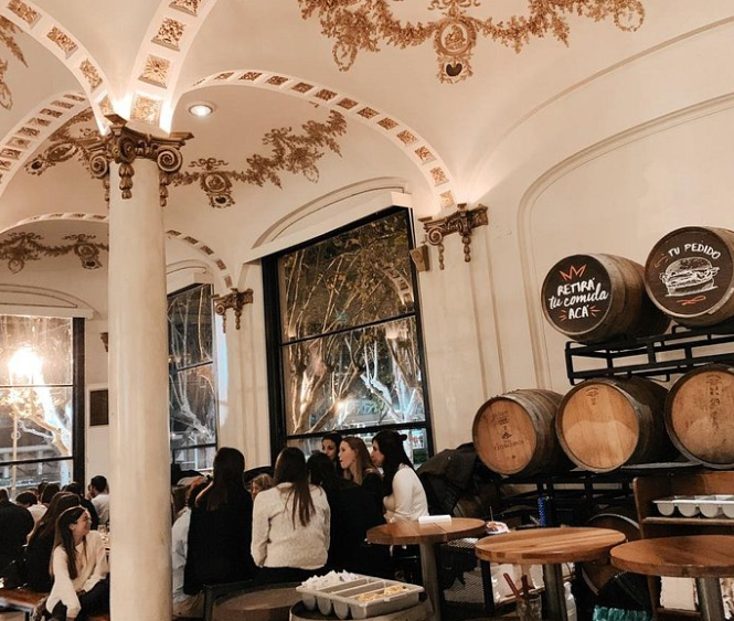 Rabieta est l'une des brasseries les plus spectaculaires de Buenos Aires, installée dans l'historique salon de thé La París de l'Hippodrome de Palermo. De jour, la façade parisienne et l'espace monumental impressionnent déjà. Mais de nuit, avec les jeux de lumières colorées, les lanternes allumées et un groupe en live en fond sonore, le lieu se transforme en quelque chose de difficile à égaler sur la scène brassicole portègne. Photo : Rabieta