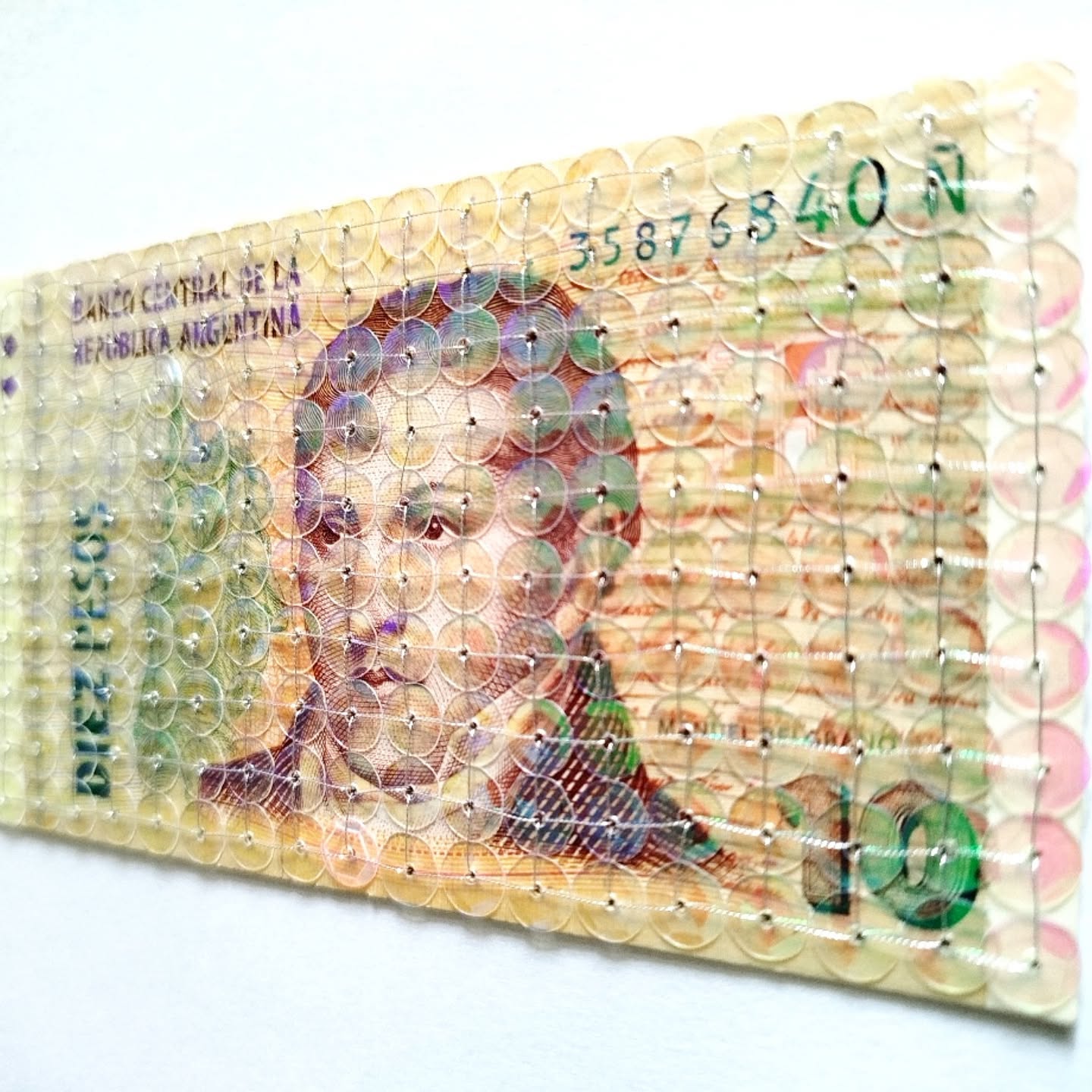 Obra de Sophie Spandonis, "Valor agregado II", billete intervenido con lentejuelas e hilo metalizado, 30x21 cm, 2025. Foto: DR Sophie Spandonis.