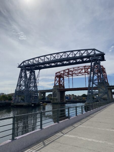 Au premier plan : le pont transbordeur relie La Boca et l'Isla Maciel, mais il n'est actuellement pas en service. À l'arrière : la passerelle piétonne. Photo : Juan Ignacio Gareca.