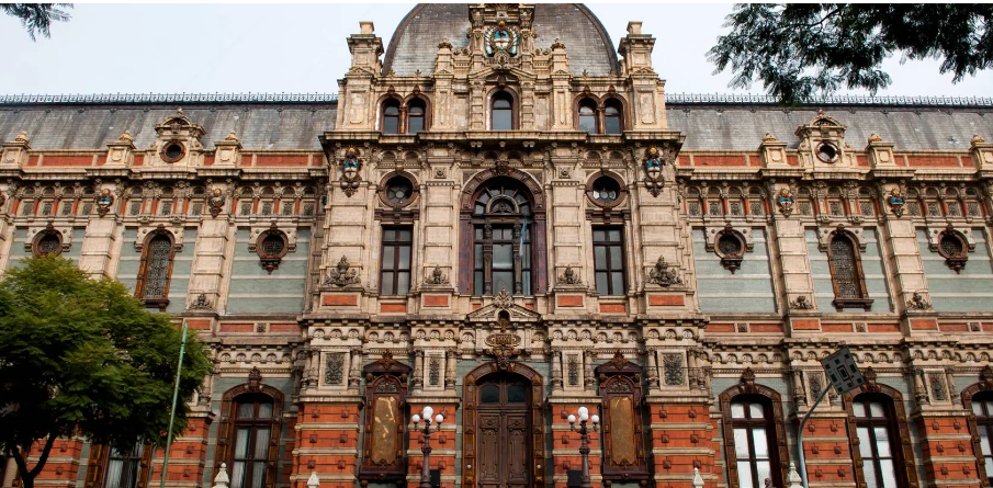El Museo de Aguas Corrientes. Lo que parece un palacio es en realidad un tanque de agua. Construido entre 1887 y 1894, este Monumento Histórico Nacional fue diseñado por un arquitecto noruego y una empresa de ingeniería británica para resolver un problema urgente: abastecer a Buenos Aires después del trauma de la epidemia de fiebre amarilla de 1871. Su fachada está cubierta por 300.000 piezas de terracota esmaltada importadas de Royal Doulton (Londres) y Burmantofts (Leeds), cada una numerada y ensamblada como un rompecabezas gigante.